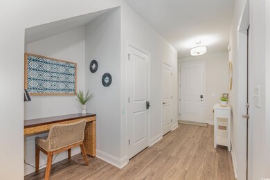 Corridor with light wood-style flooring and an office area