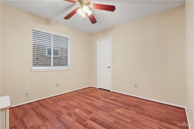 Unfurnished room featuring a ceiling fan, a textured ceiling, baseboards, and wood finished floors