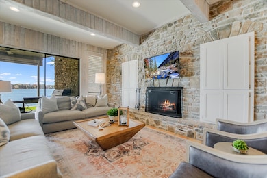 Living room with beam ceiling, a water view, and 