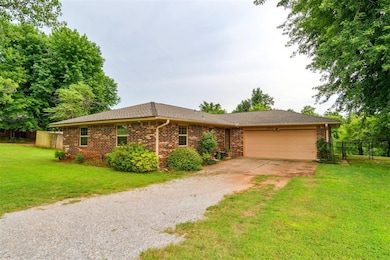 Ranch-style home featuring driveway, a garage, brick siding, and a shingled roof