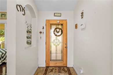 Doorway to outside featuring baseboards, arched wa