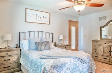 Carpeted bedroom featuring ceiling fan and a textured ceiling