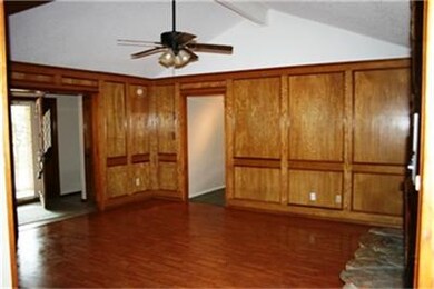Living room with rich paneling and wood floors