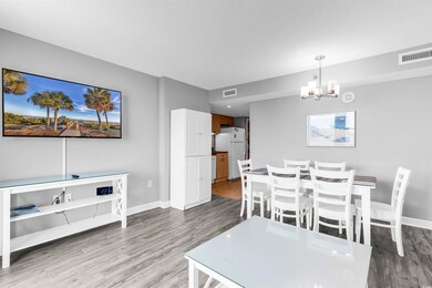 Dining area with wood finished floors, a chandelier, and baseboards