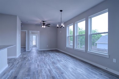 Spare room with ceiling fan with notable chandelie