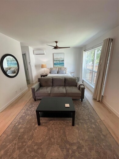 Living area with a wall mounted AC, wood finished