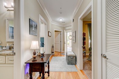 Corridor with crown molding, a sink, light wood-st