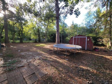 View of yard featuring a trampoline and a storage shed