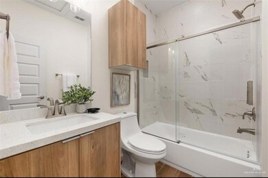 Washroom with stacked washer / drying machine, visible vents, laundry area, and wood finish floors