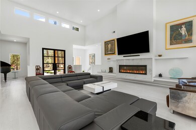 Living area with a high ceilings, commercial grade, luxury vinyl flooring, LED flush mount with high efficiency puck lights, and a glass covered propane fireplace, & 85