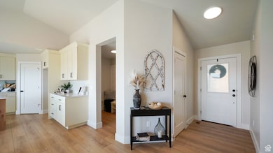 Entryway featuring lofted ceiling and light wood-style floors