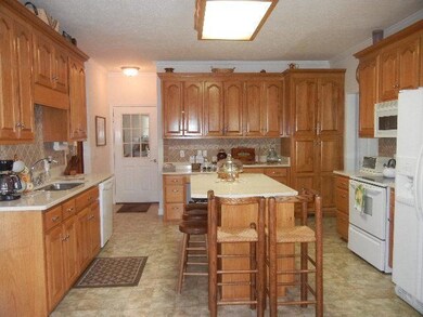 Chef's dream of a Kitchen such as this with it's abundance of cabinet space & solid surface countertops. A huge Island allows for additional seating.  The desk area is perfect for doing homework.  