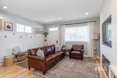 Living room with light wood-style flooring, recessed lighting, and a glass covered fireplace