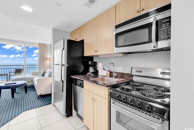 Kitchen with visible vents, stainless steel appliances, light brown cabinetry, a sink, and light tile patterned flooring