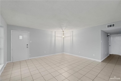 Spare room with light tile patterned floors and a textured ceiling