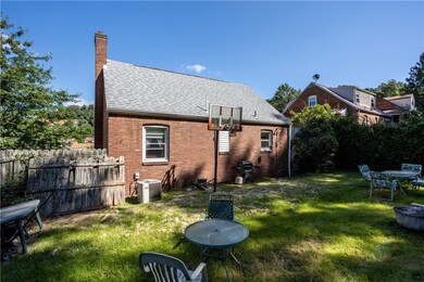 Back of the house with a side fence and hedges for