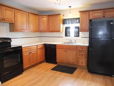 Fully applianced kitchen with tile backsplash.