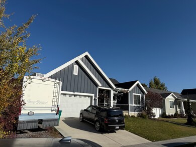 View of front of house featuring board and batten siding, driveway, a garage, and a front yard