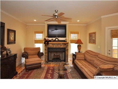 THE LIVING ROOM IS 12 X 20 WITH SMOOTH CEILING, CROWN MOULDING, STONE FIREPLACE, PINE HARDWOOD FLOORING, WINDOW TREATMENT AND CEILING FAN