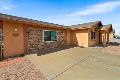 View of front of house featuring a shingled roof, stone siding, and stucco siding