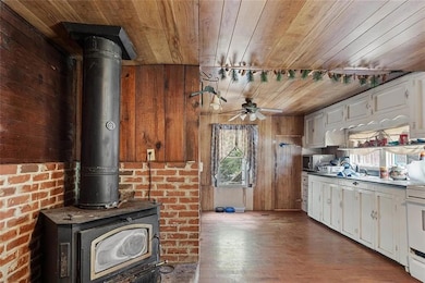 Kitchen with wooden walls, white cabinets, a wood 