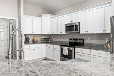Kitchen featuring white cabinetry, stainless steel
