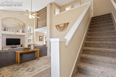 Stairway with high vaulted ceiling, ceiling fan, a
