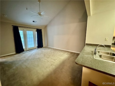 Living area with ceiling fan, lofted ceiling, and