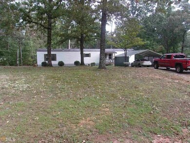 View of front of home with a detached carport and a front lawn