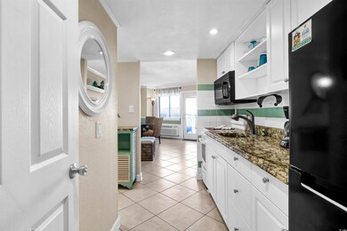 Kitchen with black appliances, dark stone counters