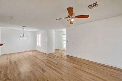 Unfurnished living room with light wood-type flooring, ceiling fan, and a chandelier