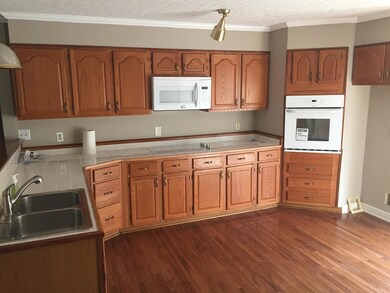 A view of the large kitchen with  new microwave, stove and oven. 