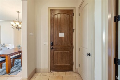 Doorway to outside with baseboards and a notable chandelier