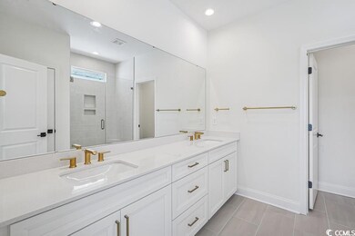Bathroom featuring a shower stall, double vanity, 
