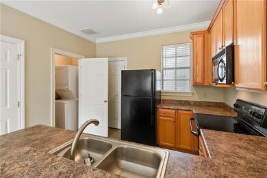 View of Kitchen, Laundry Area with stacked Washer/