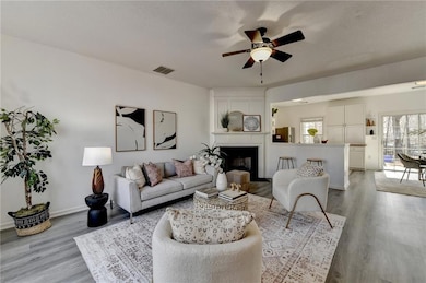 Living area featuring a large fireplace, ceiling f