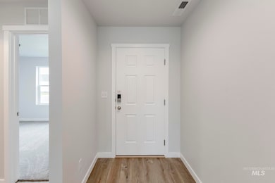 Doorway to outside featuring baseboards and wood finished floors