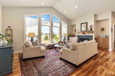 Living room featuring light wood-style flooring, a fireplace, vaulted ceiling, and recessed lighting