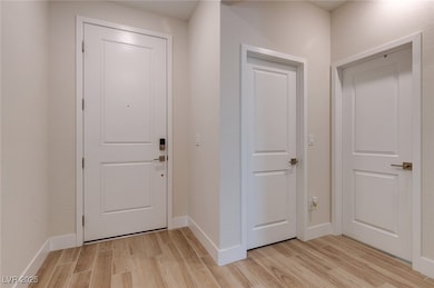 Entryway with light wood-style flooring and basebo