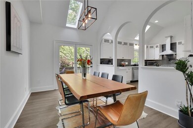 Lovely Dining room with arched walkways, wood finished floors and access to huge deck for effortless entertaining