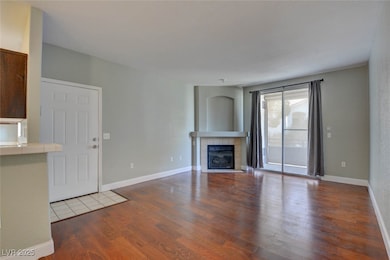 Unfurnished living room featuring wood finished fl