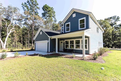 View of property featuring a garage and a front lawn