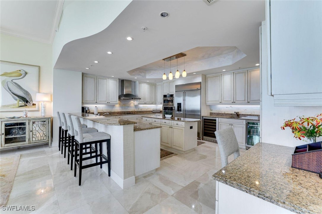 Kitchen featuring wall chimney range hood, a kitch