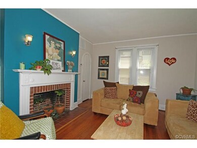 Sunny Family/Living room with fireplace, hardwood floors, picture molding, pineapple wall sconces and arched doorways.