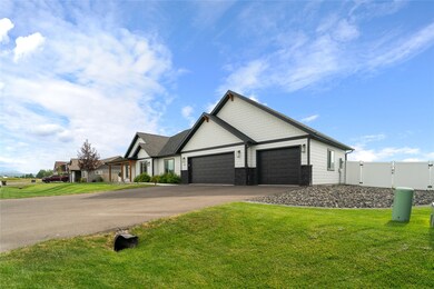 View of front facade with a garage, asphalt driveway, a gate, and stone siding