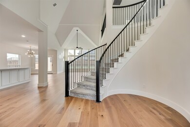 Stairs with wood finished floors, a chandelier, recessed lighting, a high ceiling, and ceiling fan