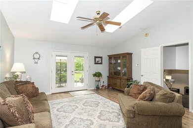 Living room with newer flooring opens to the spacious back yard with patio and mature trees! Skylights offer tons of natural light.