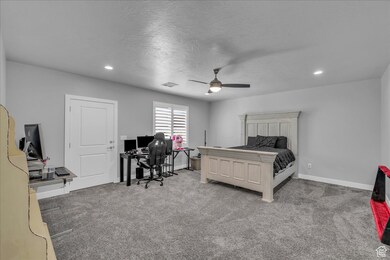 Bedroom with a desk, light colored carpet, a ceiling fan, recessed lighting, and a textured ceiling