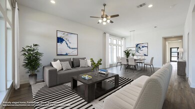 Living area with ceiling fan, wood finished floor