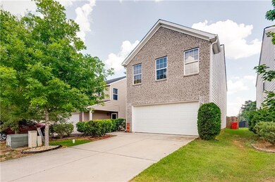 Traditional-style house with brick siding, an attached garage, driveway, and a front yard